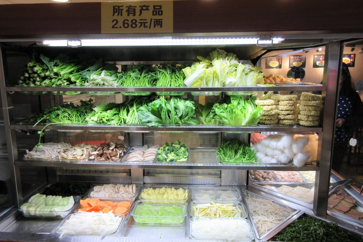 Raw hotpot ingredients — vegetables and noodles arranged for the table