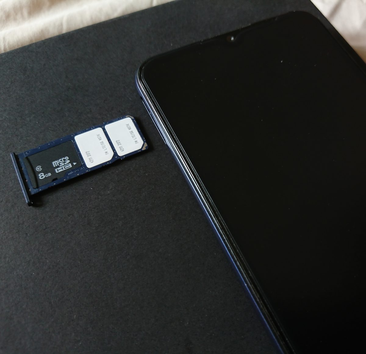 A smartphone showing an eSIM install screen beside a SIM card
