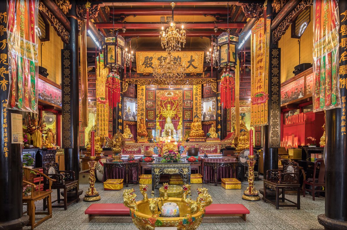 A camera held up to photograph a temple courtyard