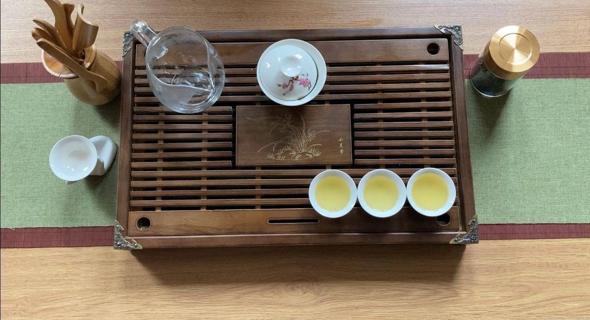 A Chinese tea ceremony with a gaiwan and small cups